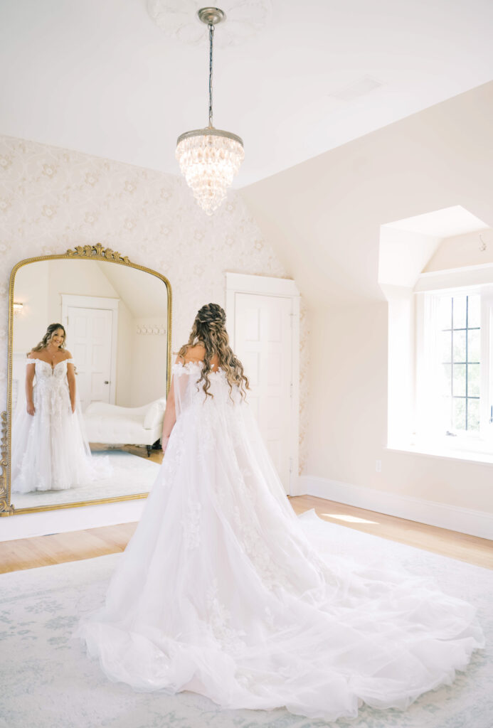 bride looking in gold mirror in getting ready room at Venue2Two with a wedding photographer in Grand Rapids