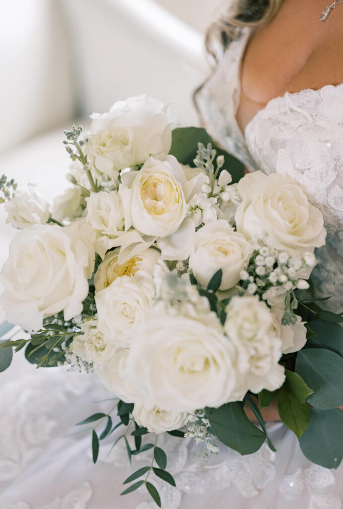 bride holding white rose wedding flowers