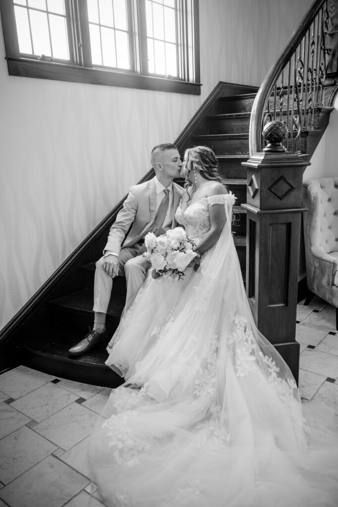 a bride and groom sitting on the staircase inside Venue3Two by a Grand Rapids wedding photographer