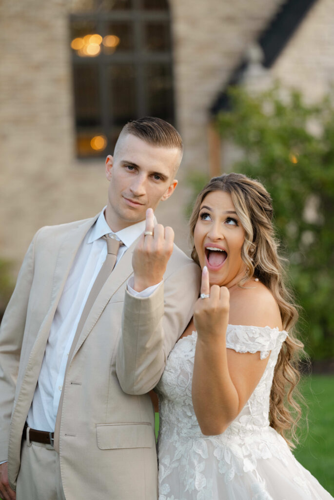 a bride and groom show off their wedding rings to their top Michigan wedding photographer