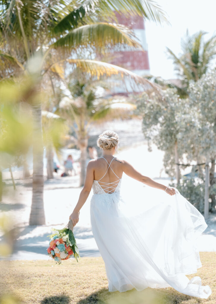 A bride twirls her dress by palm trees at a cruise wedding port