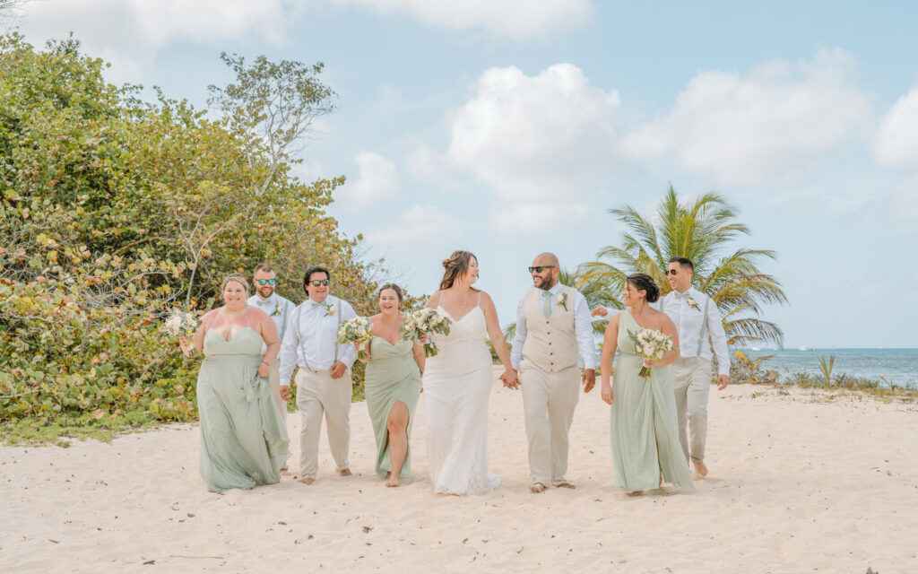 A wedding party walks along the beach at a destination wedding in Cozumel