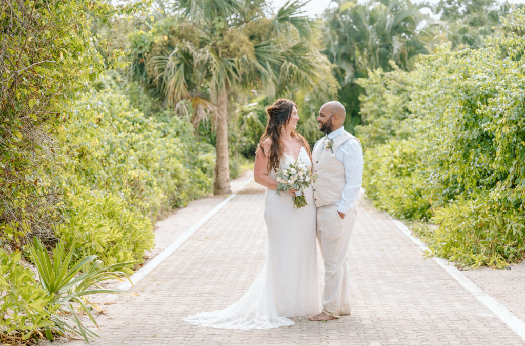 A bride and groom walk along a palm with their cruise wedding photographer in Cozumel at Mr Sanchos
