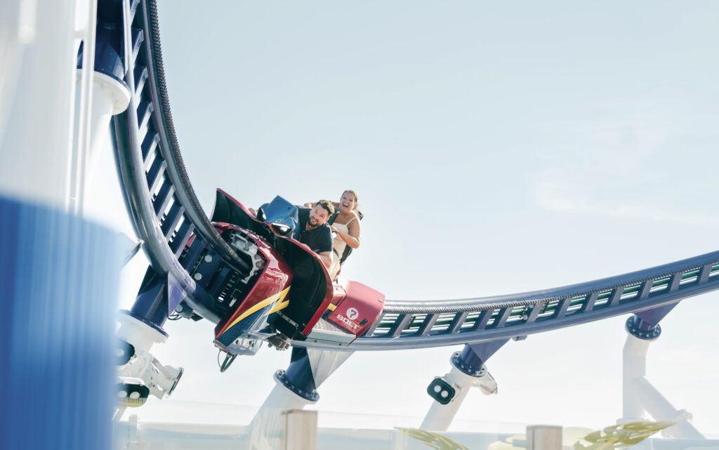 A bride and groom take a ride on a rollercoaster on their cruise ship